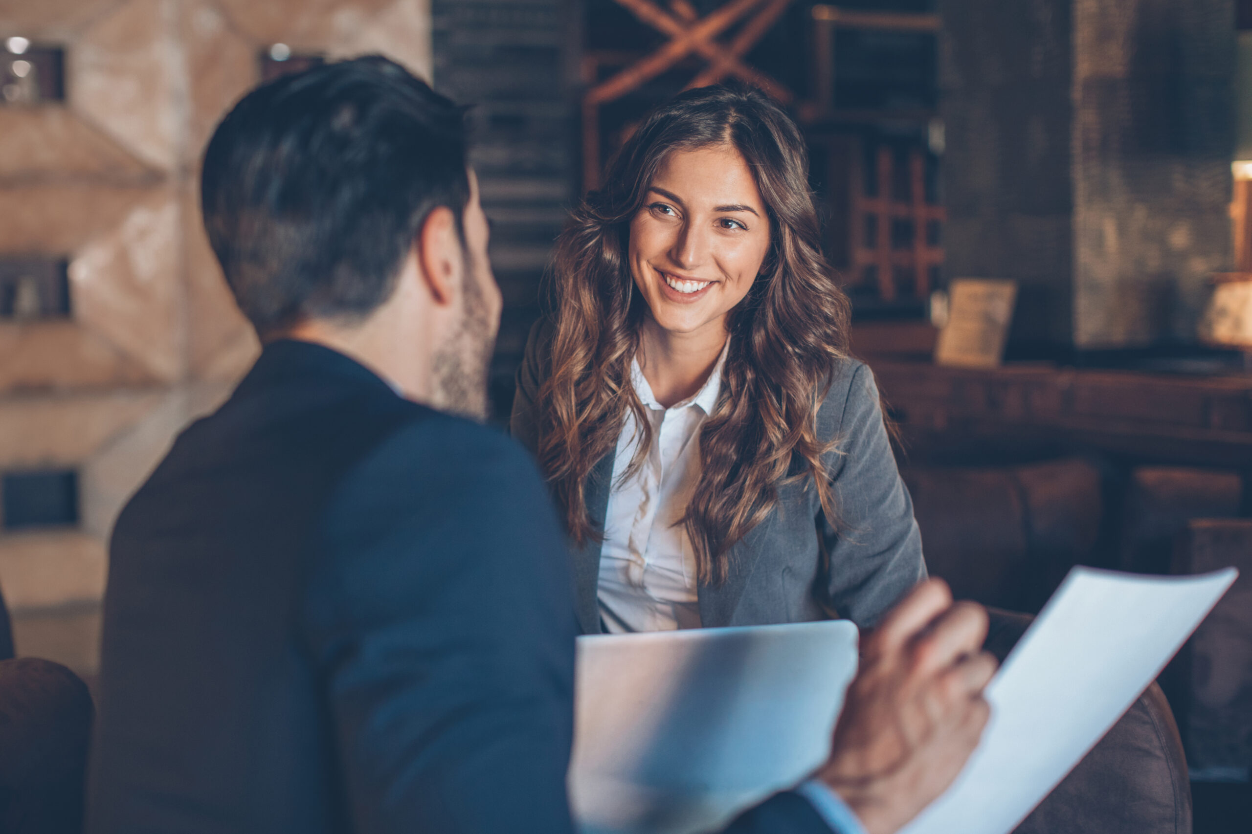 Two people in formal business wear talking and smiling